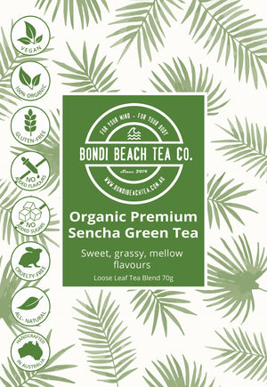 Bondi Beach Tea Co.s Organic Premium Sencha Green Tea label showcases vegan, organic, gluten-free, no added sugar, cruelty-free, non-GMO, and Australian-made logos. It highlights sweet, grassy flavors rich in antioxidants against a leaf-patterned background.