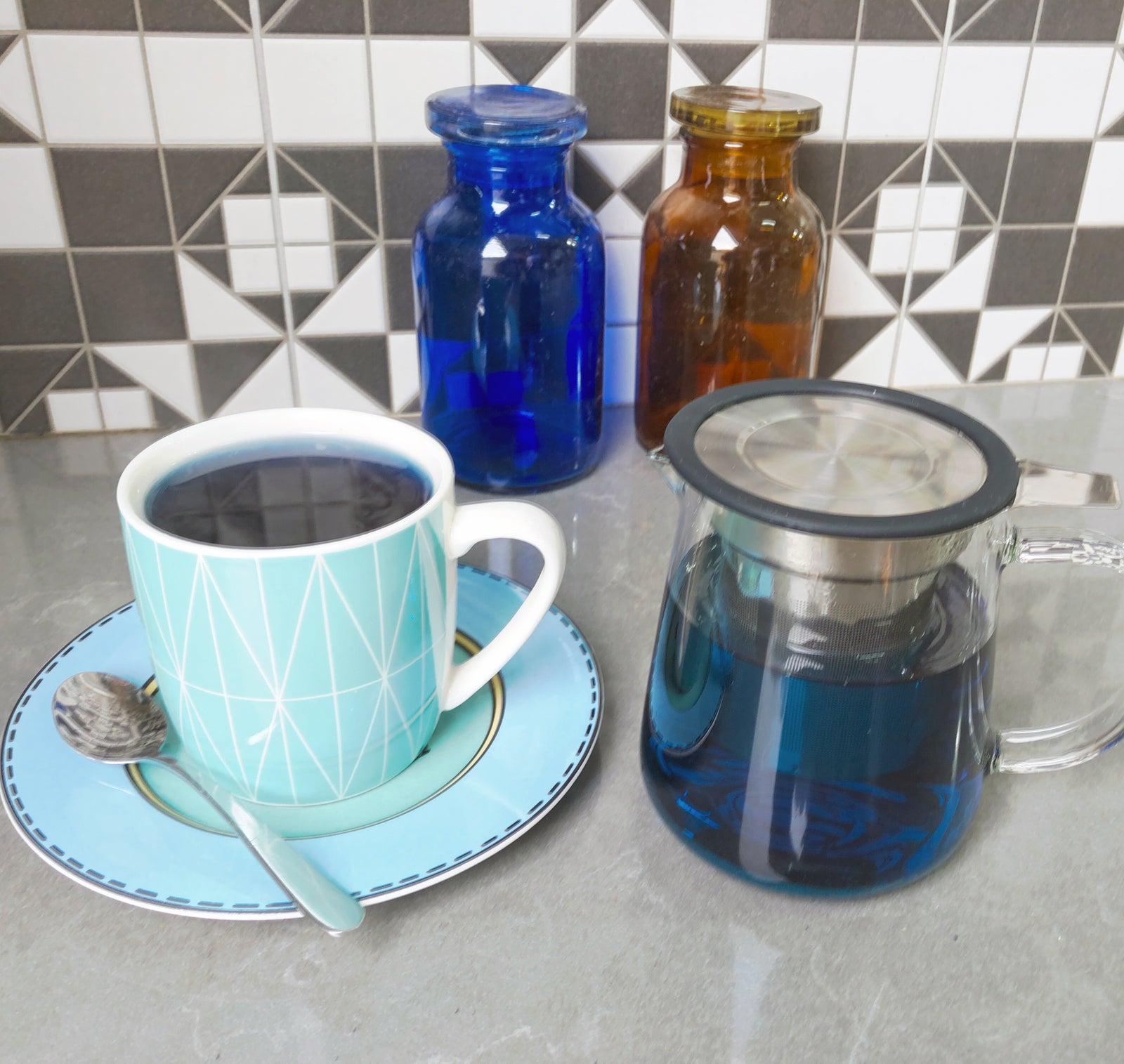 A close-up of Organic Blue Butterfly Pea Flowers from Bondi Beach Tea Co scattered on a white background highlights their vibrant deep blue, light green, and yellow petals, reflecting their antioxidant-rich nature ideal for brewing colorful herbal tea.