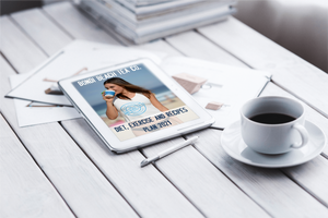 A tablet on a white wooden table shows the Bondi Beach Tea Co. Diet, Exercise and Recipes eBook featuring a woman with a cup. Nearby are weight loss teas, a pen, and scattered papers alongside Bondi B-Slim program essentials.