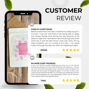 A smartphone showcases reviews of Bondi Snooze Tea 💤 by Bondi Beach Tea Co; Zixing observes better sleep, and Tara commends its effectiveness. The organic, caffeine-free nighttime tea is placed on a cloth beside green leaves.