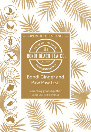 Label for Bondi Beach Tea Cos Bondi Organic Ginger and Paw Paw/Papaya Leaf Tea with icons for vegan, organic, gluten-free, no added flavors, cruelty-free, all-natural. Promotes good digestion against a leafy backdrop.