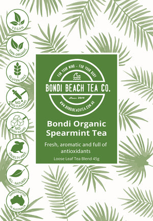 A green and white Bondi Beach Tea Co. package labeled Spearmint Leaf Tea - Organic showcases icons for vegan, organic, gluten-free, no added flavors, caffeine-free, cruelty-free, all-natural health benefits, and Australian-made amidst leaf patterns.