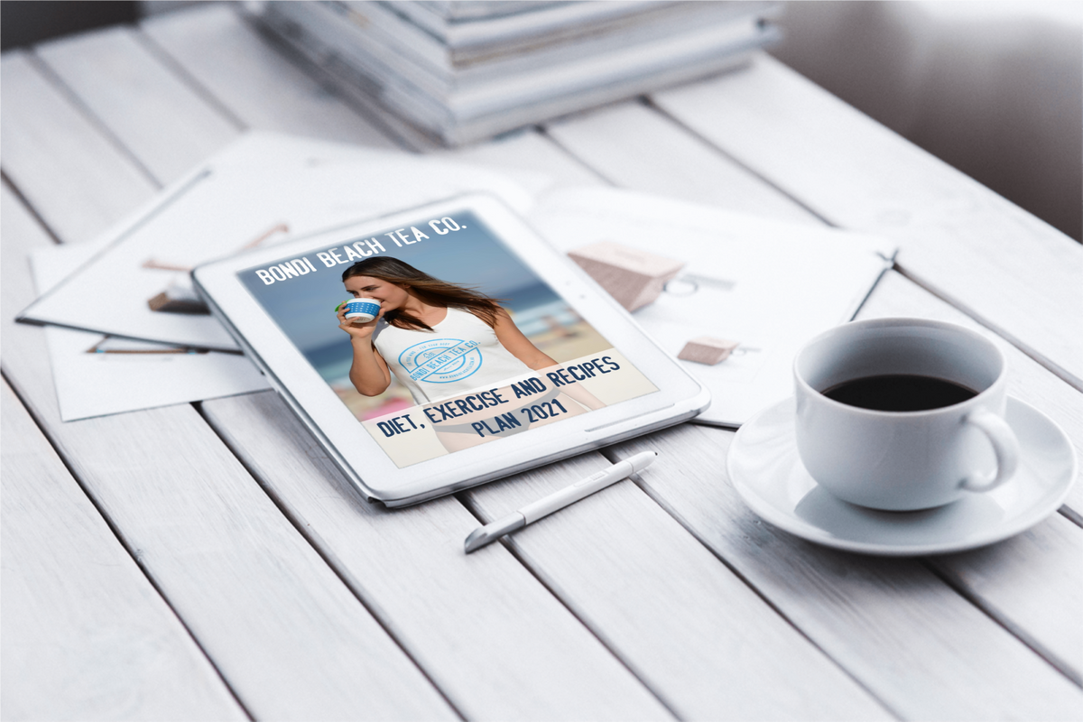 A tablet on a white wooden table shows the Bondi Beach Tea Co. Diet, Exercise and Recipes eBook featuring a woman with a cup. Nearby are weight loss teas, a pen, and scattered papers alongside Bondi B-Slim program essentials.